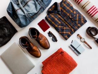 Above shot of arranged mens traveling related staff, shoes, shirt, passport…